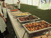 Uncovered outdoor buffet line at a catered hog roast event